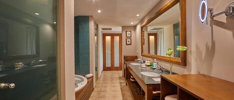 Un baño moderno con dos lavamanos, un espejo grande y un tocador con repisas.
