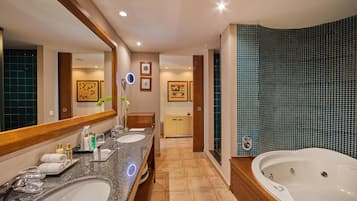 A modern bathroom with two sinks, a large mirror, a bathtub, and a vanity with a mirror.
