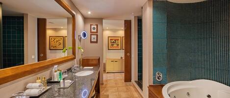 A modern bathroom with two sinks, a large mirror, a bathtub, and a vanity with a mirror.