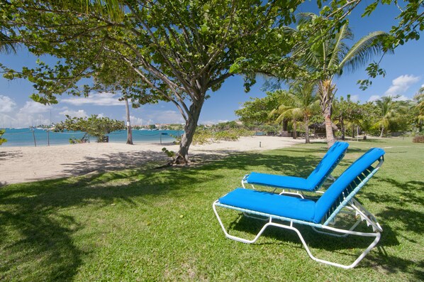 Aan het strand, wit zand, ligstoelen aan het strand, parasols
