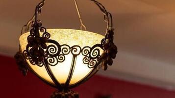 A hanging light fixture with a glass shade and decorative metalwork.