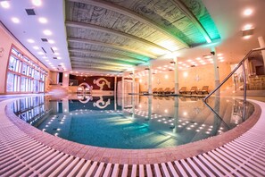 Una piscina cubierta, una piscina al aire libre, tumbonas