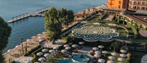 Un complexe hôtelier doté d’une grande piscine, de chaises longues et offrant une vue sur la mer.