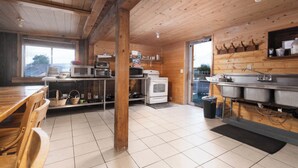 Un interno in legno con angolo cottura, dotato di fornelli, forno a microonde e lavello.
