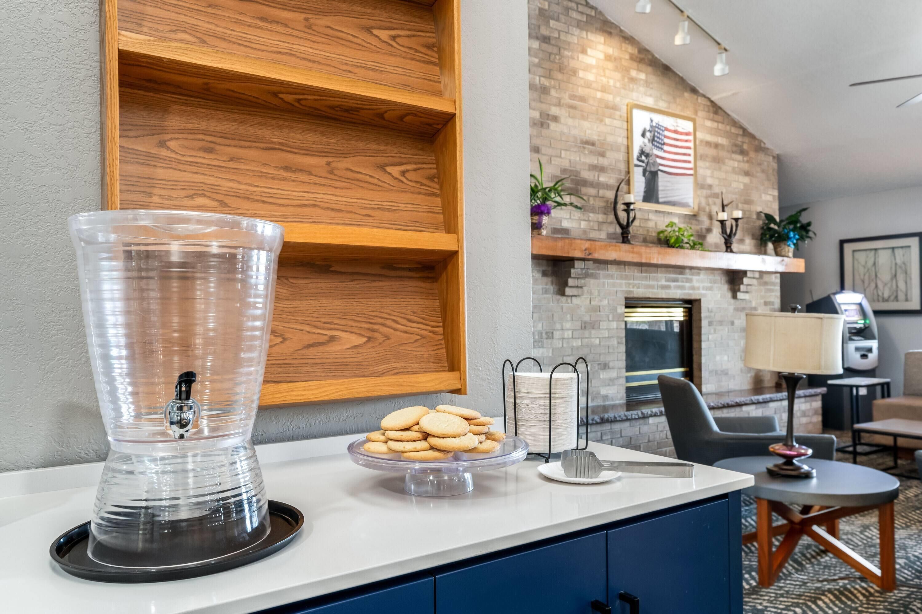 A kitchen area with a blender, a plate of cookies, and a coffee machine.