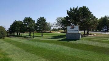Señal de Heston Golf Park con césped cuidado y árboles.