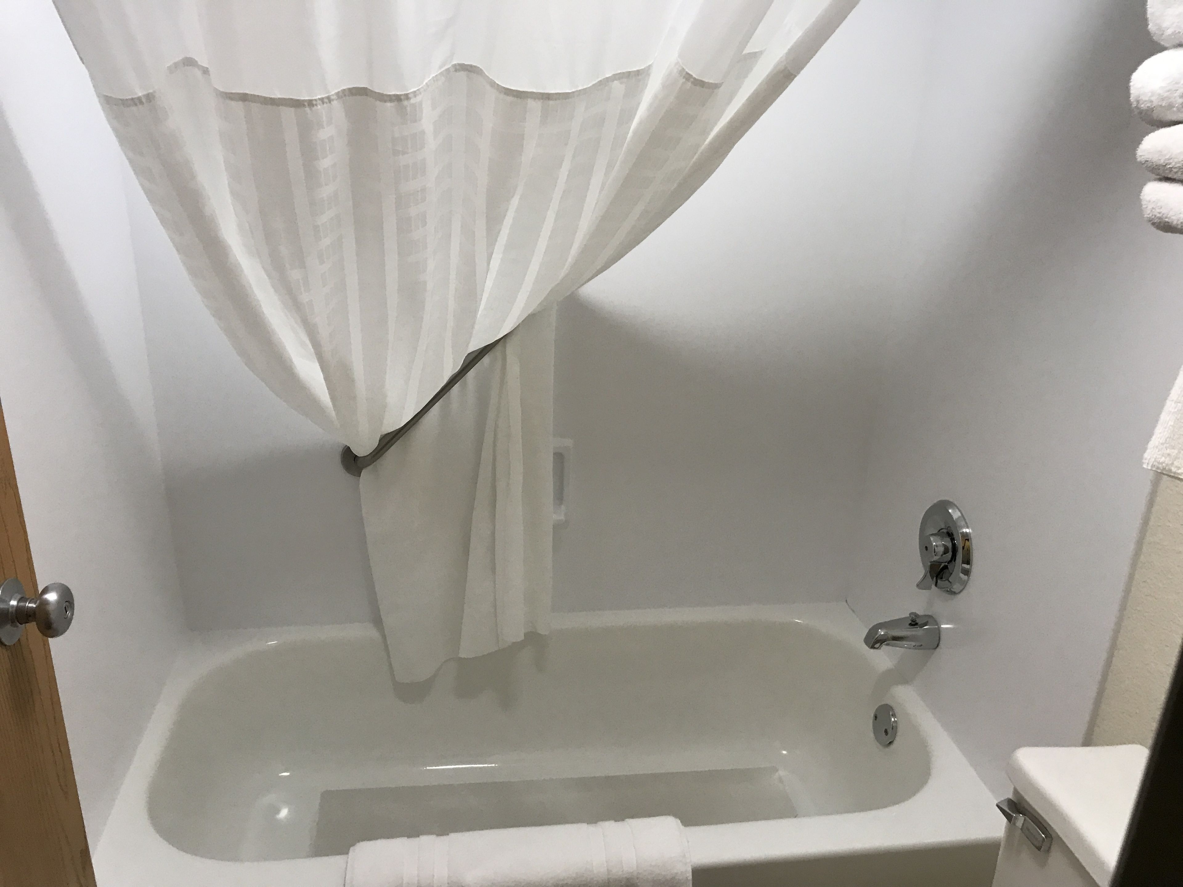 Un baño con bañera, cortina de ducha y retrete.