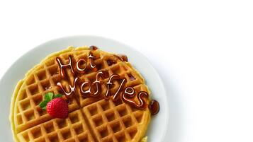 A plate with a waffle and syrup, with the text "Hot Waffles" written on it.