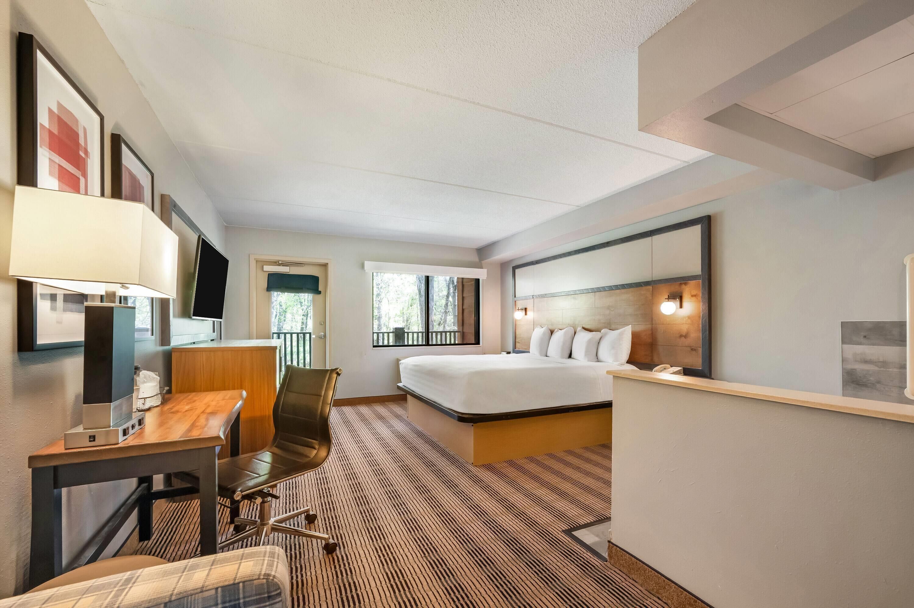Une chambre d’hôtel équipée d’un lit, d’un bureau, d’une chaise et d’un téléviseur.