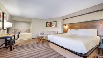 A hotel room with a bed, desk, chair, and a small table.