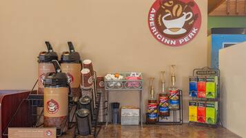 A coffee station with Americinn Perk branded coffee makers, a Bigelow tea dispenser, and Torani chocolate syrup.
