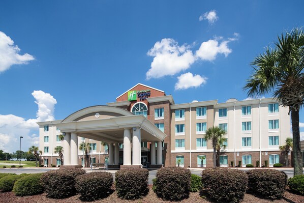 A Holiday Inn Express hotel with a central entrance, multiple floors, and a brick facade. - Holiday Inn Express & Suites Florence I-95 @ Hwy 327 by IHG (Florence)