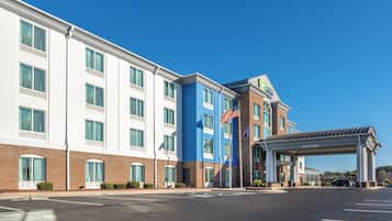 A hotel with a modern design, featuring a prominent entrance with a covered walkway and an American flag.