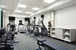 A gym with treadmills, elliptical machines, and free weights.