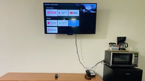 Un televisor instalado en la pared que muestra una interfaz con iconos de aplicaciones.