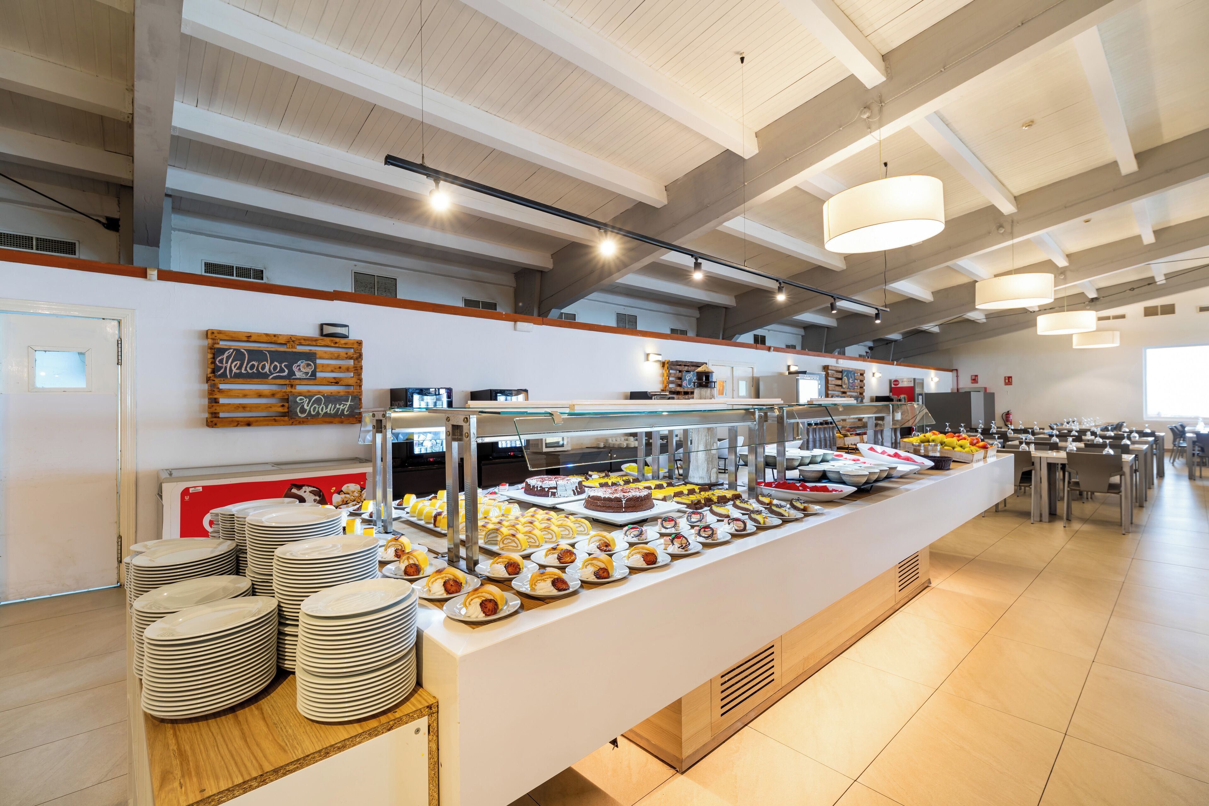 A buffet area with a variety of food items and a sign indicating 'Heloas' and 'Souvenirs'.