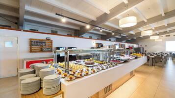 A buffet area with a variety of food items and a sign indicating 'Heloas' and 'Souvenirs'.