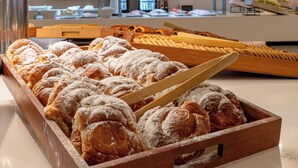 A bakery display with pastries and a wooden tray.