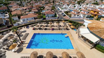 Una piscina al aire libre, sillones reclinables de piscina