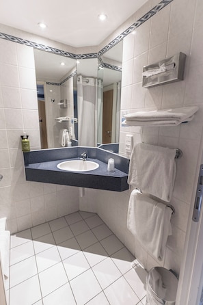 Une salle de bain moderne avec un lavabo blanc, un miroir et un porte-serviettes.