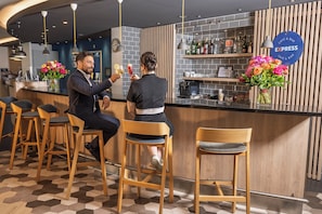 En bardisk med trästolar, en bardisk med barutrustning och en skylt som visar att det är en bar med snabb service.