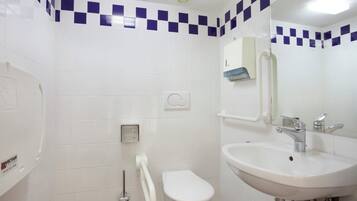 Une salle de bain avec un lavabo blanc, des toilettes et un sèche-mains.