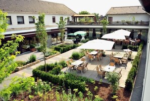 A courtyard with outdoor seating and a covered area. - Landhaus Beckmann (Kalkar)