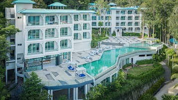 Una piscina al aire libre, sombrillas, sillones reclinables de piscina