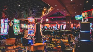 Un casino con numerosas máquinas tragamonedas y mesas de juego.