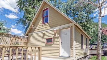 1 habitación, cubrecamas, escritorio y tabla de planchar con plancha