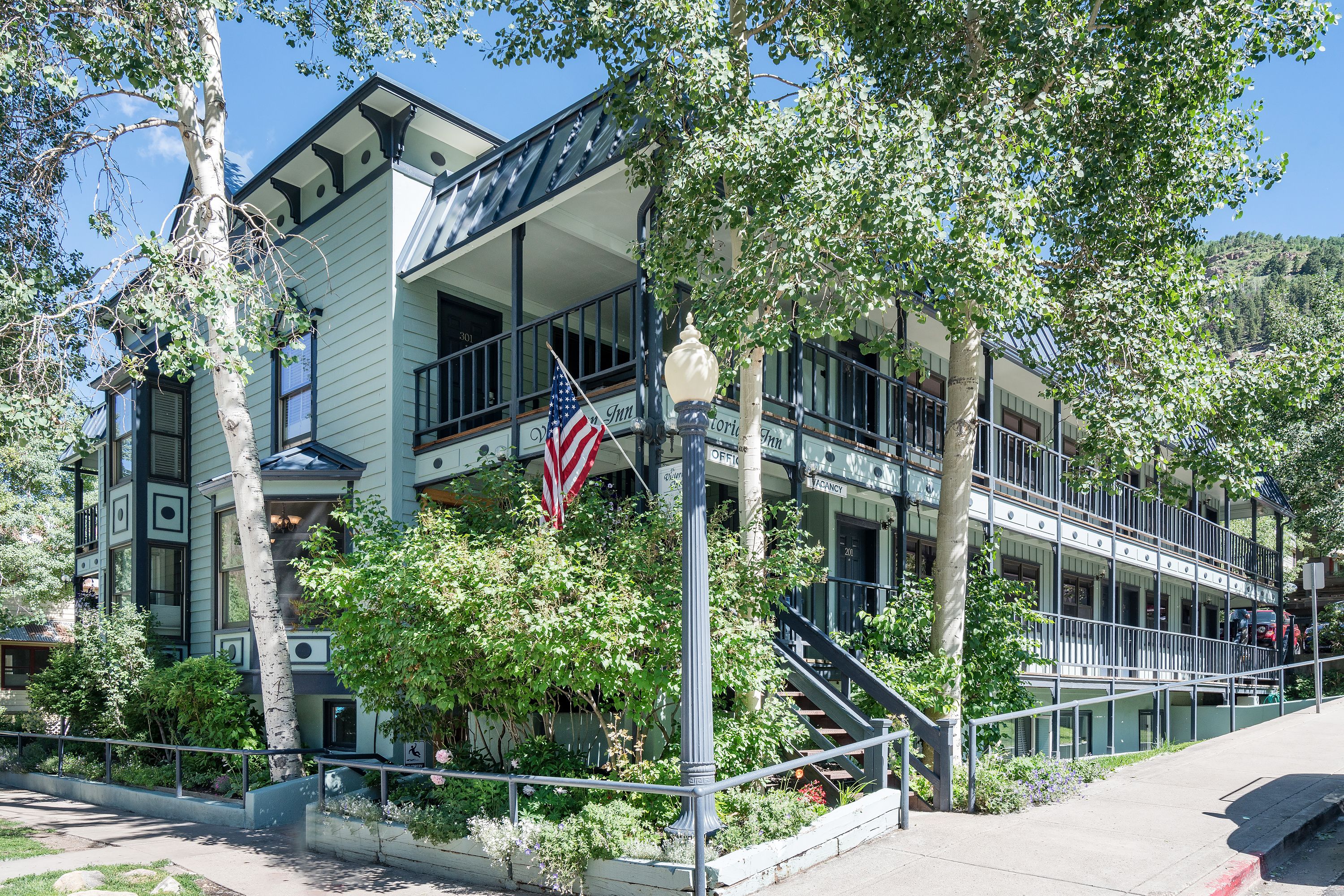 A multi-story building with a balcony, a flag, and a staircase.