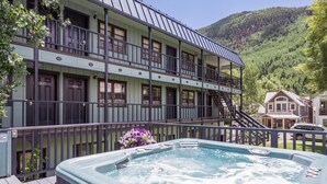 A hotel with a hot tub, balconies, and a mountainous backdrop. - The Victorian Inn (Telluride)