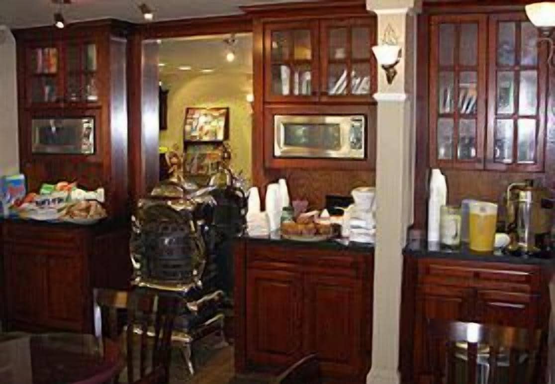 Una cocina tradicional con armarios de madera, una isla central y una zona de bar con taburetes.