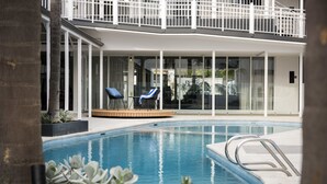 A modern hotel with a pool area, including a lounge chair and a sunbed. - Tradewinds Hotel Fremantle (East Fremantle)