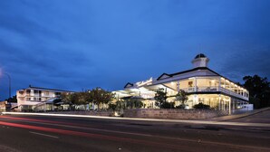 A waterfront hotel with a prominent tower, outdoor seating, and a well-lit facade. - Tradewinds Hotel Fremantle (East Fremantle)