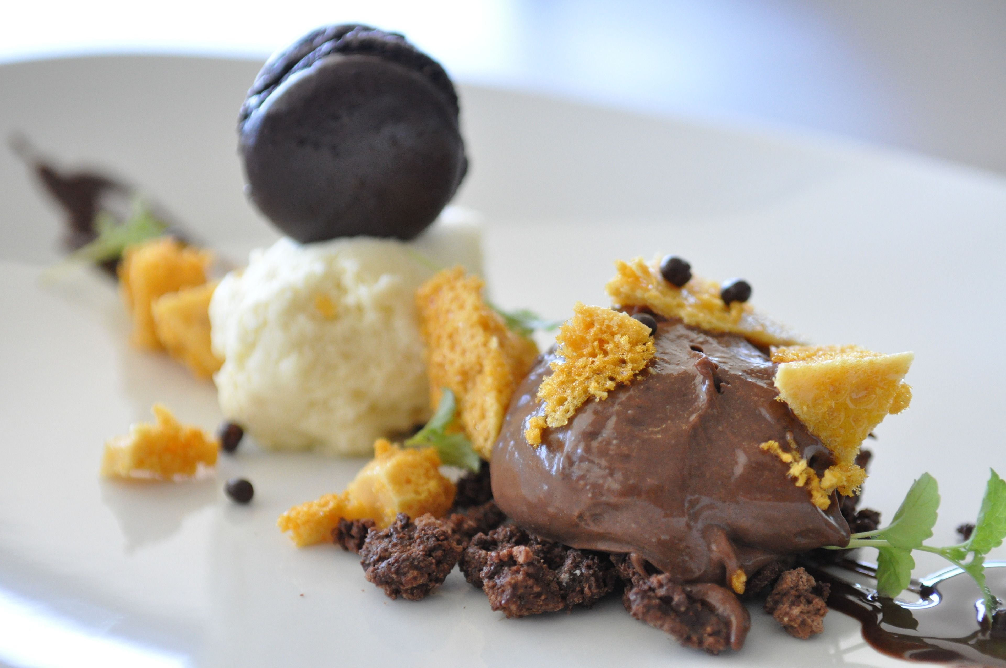A dessert plate with a chocolate dessert, a scoop of ice cream, and crumbled cookies.