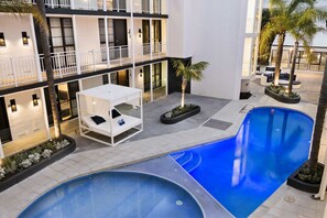 Una piscina al aire libre, camas de piscina gratis, sombrillas