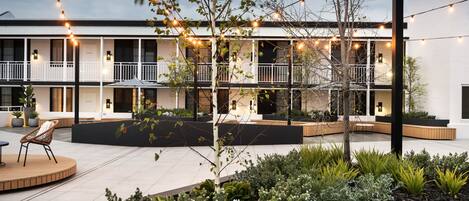 A courtyard with a seating area, plants, and string lights.