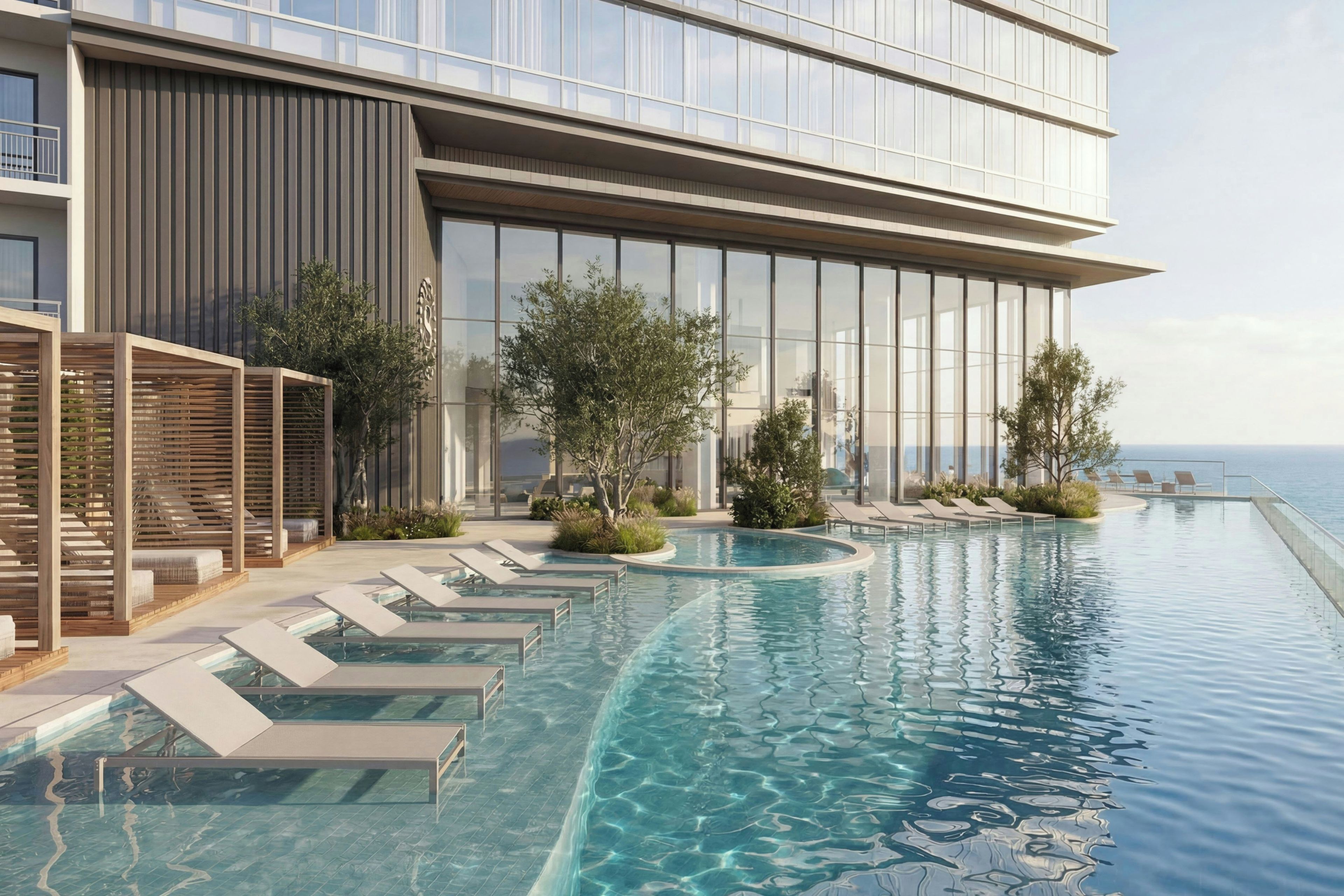 Ein modernes Hotel mit Pool, Liegestühlen und Meerblick.