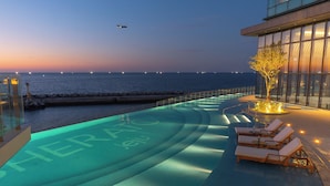 A pool with a view of the sea and a sunset.