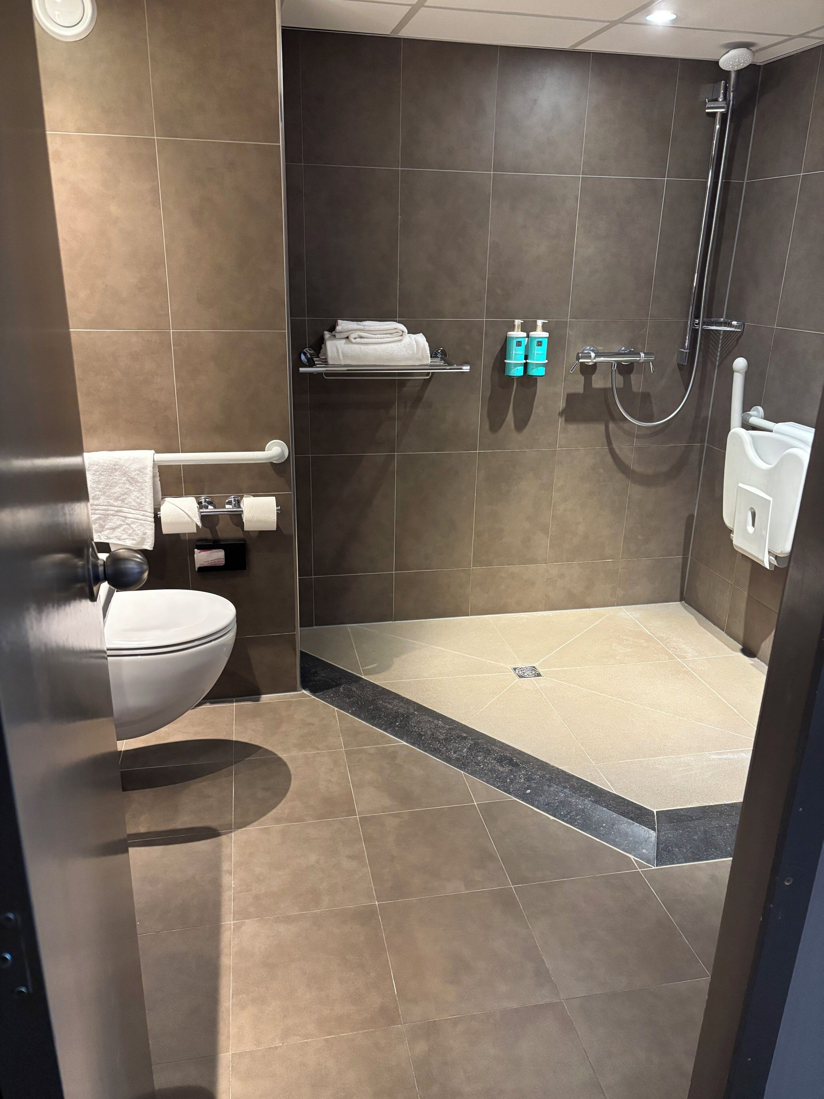 Een moderne badkamer met toilet, wastafel en douche.