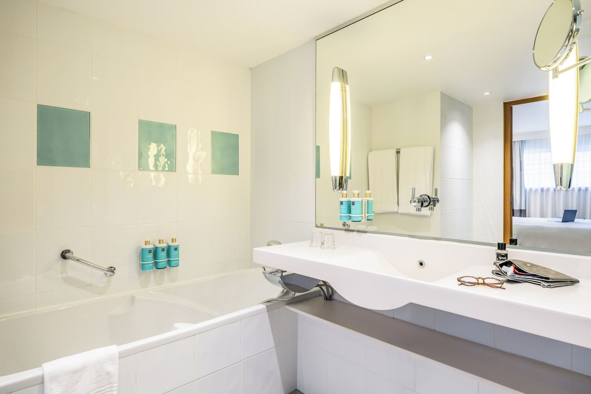 Suite Junior, 1 lit double et 1 canapé-lit | Salle de bain | Baignoire et douche séparées, articles de toilette écologiques