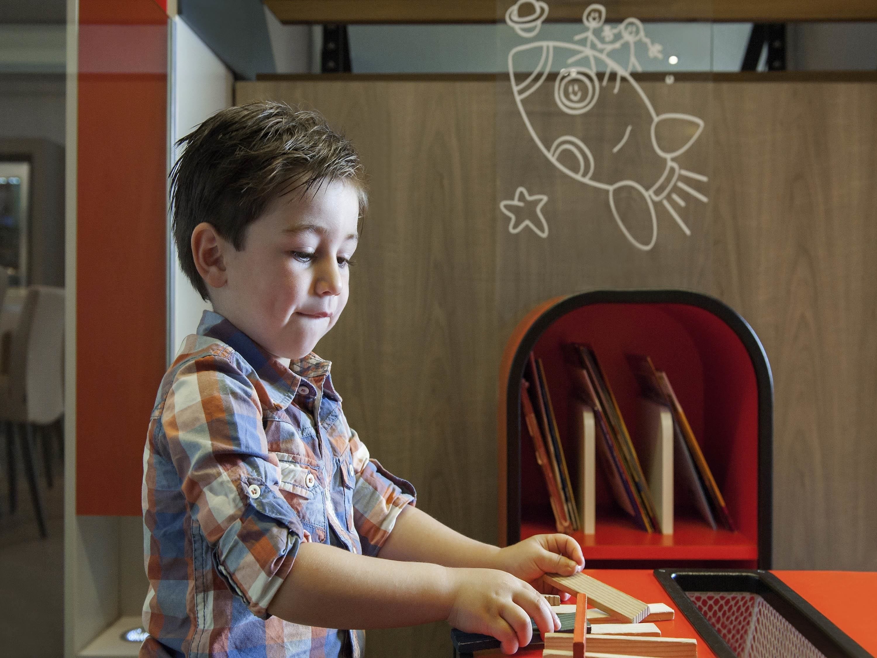 Un niño jugando con bloques de madera en una mesa.