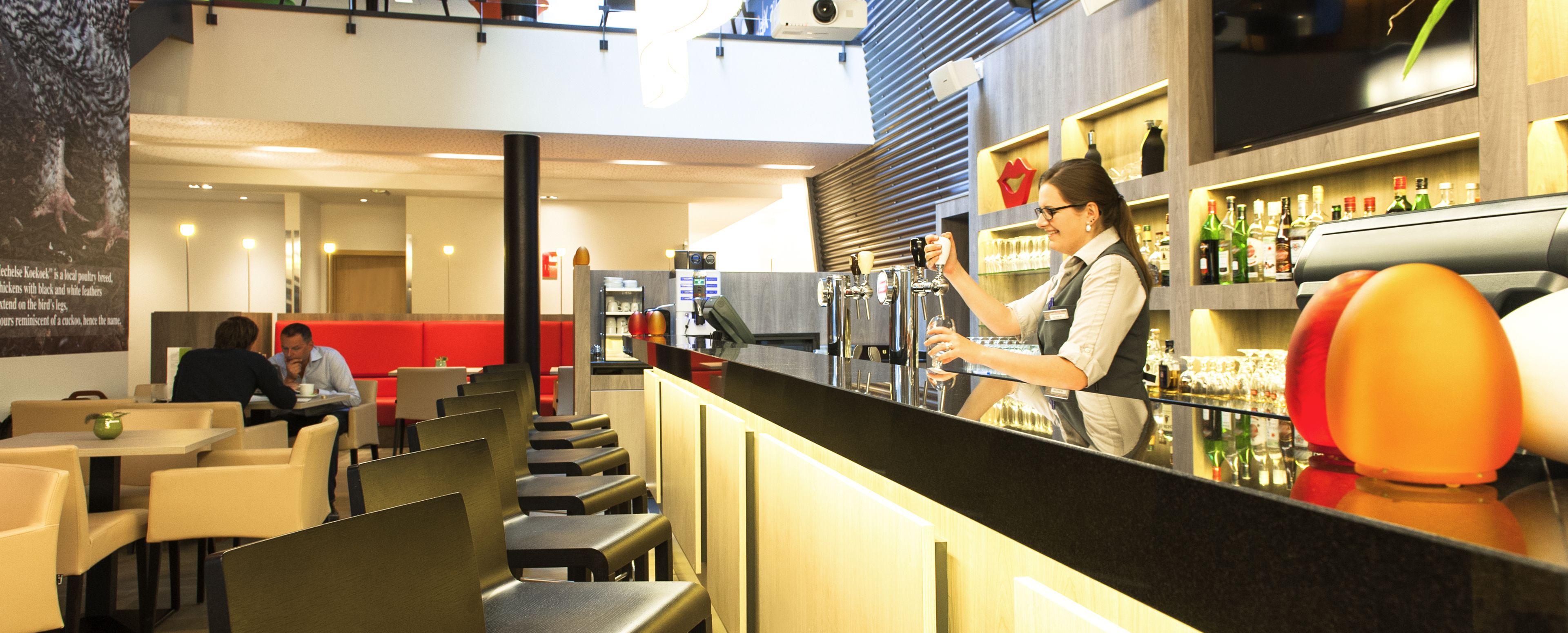 Ett modernt barområde med en bartender, sittplatser och bardisk.