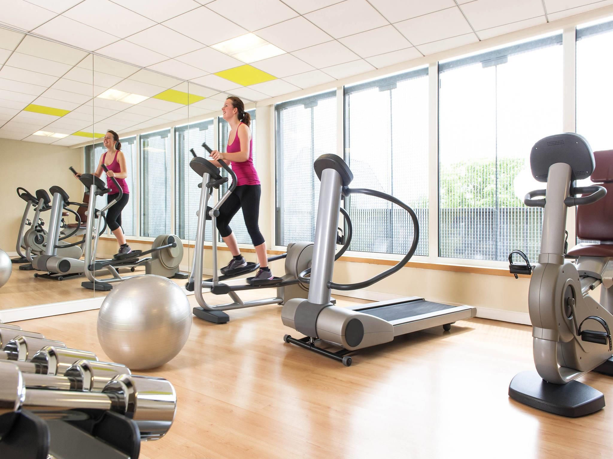 Een fitnessruimte met loopbanden, elliptische trainers en fitnessballen.