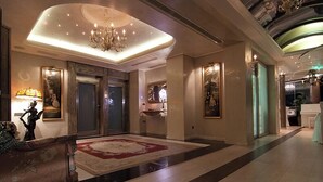 A spacious lobby with a grand chandelier, a red carpet, and a large painting on the wall. - Athenian Callirhoe Hotel (Athens)