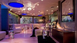 A modern lounge area with a sofa, coffee table, and decorative items. - Athenian Callirhoe Hotel (Athens)