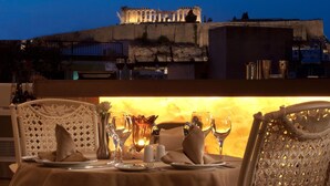 A table set for dining with a view of ancient ruins at dusk. - Athenian Callirhoe Hotel (Athens)