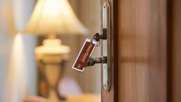 A hotel room door with a keycard holder displaying "Hotel 28" and a lamp in the background.
