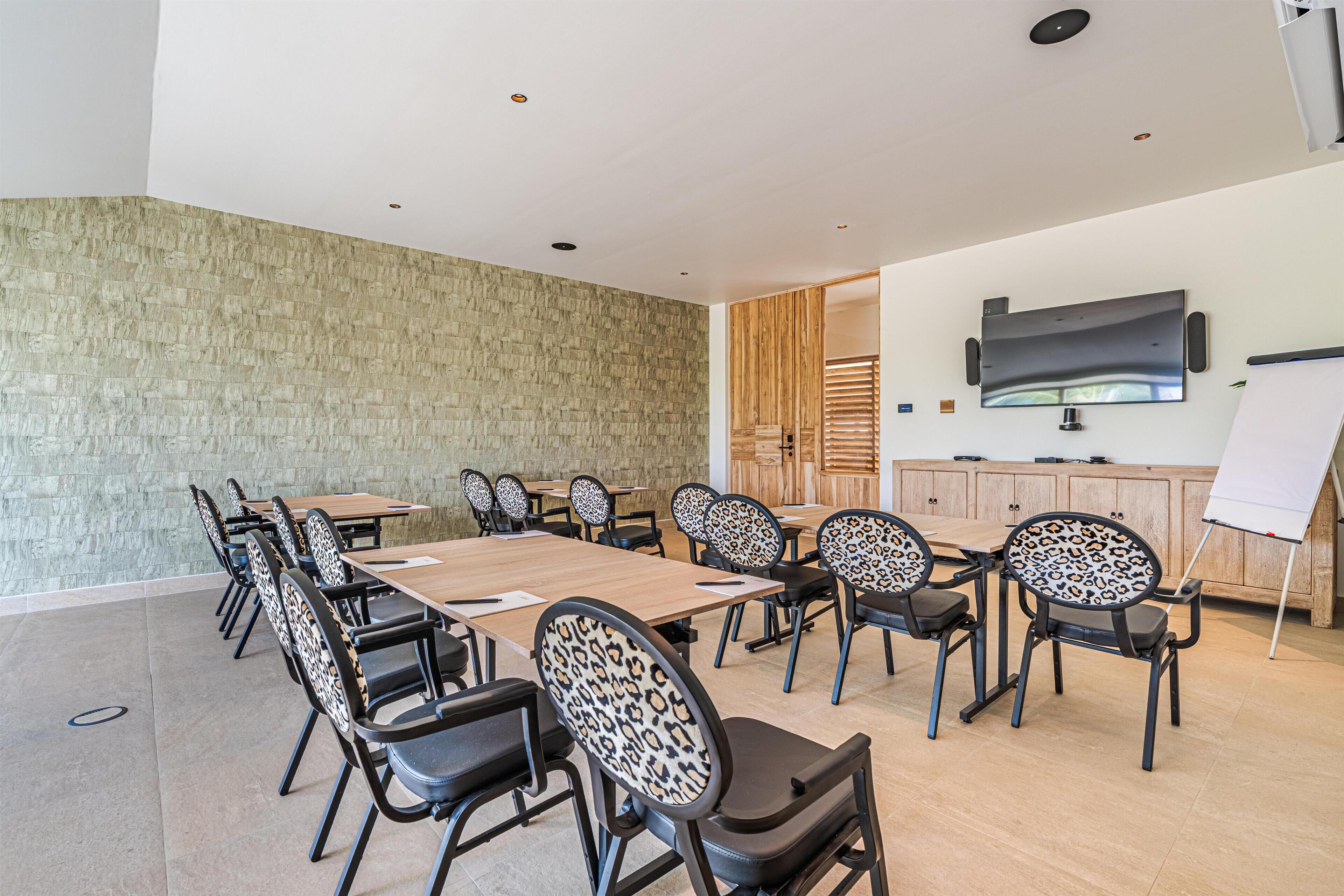 A conference room with a large table, chairs, a whiteboard, and a television on the wall.
